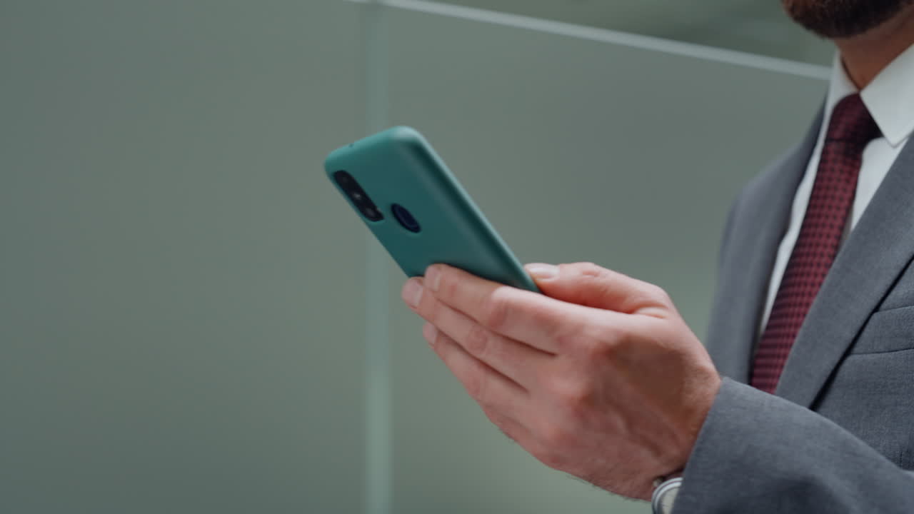 Closeup going manager messaging smartphone. Businessman hands browsing phone