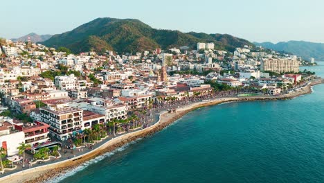 pride parade passing through downtown puerto vallarta mexico at sunset, church standing out in background