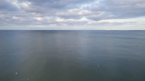 vast and sweeping horizon in the baltic sea near gdynia, poland with sight of paddleboarders