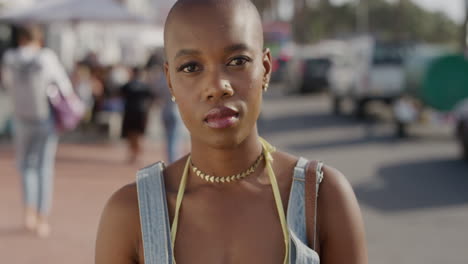retrato de una hermosa joven mujer afroamericana que parece tranquila y pensativa disfrutando de una cálida playa urbana soleada