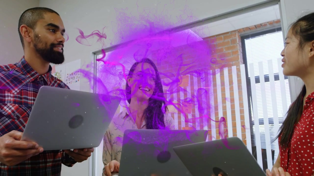 Video vertical: Hablando, equipo sosteniendo portátiles y colaborando en la oficina, humo morado creciendo.