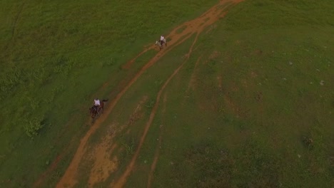 slow motion aerial view of two riders galloping their horses in a venezuelan plain
