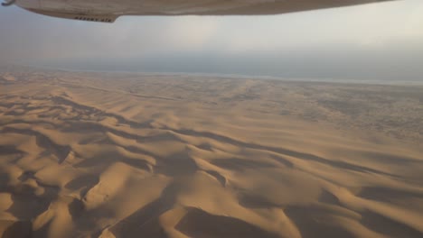 amplia toma épica de la costa de los esqueletos, namibia, tomada desde un pequeño avión con algunas turbulencias y nubes