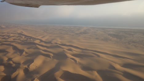 wide epic shot of the skeleton coast, namibia, shot froma small airplane with some turbulence and clouds