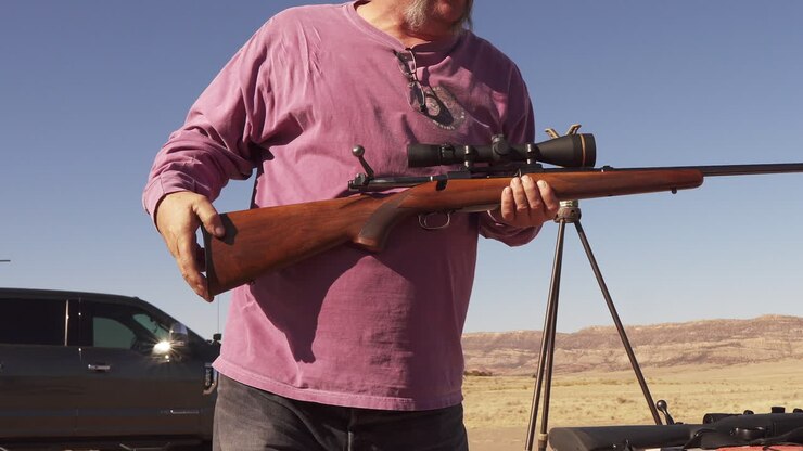 Man clears his rifle at the shooting range and places it down