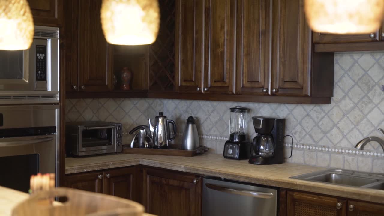 cucina con mobili in legno, rubinetto, forno, rubinetteria e lampadari