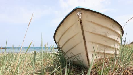 Barco-De-Madera-En-La-Orilla-Cubierta-De-Hierba-En-La-Playa-De-Bolata,-Bulgaria