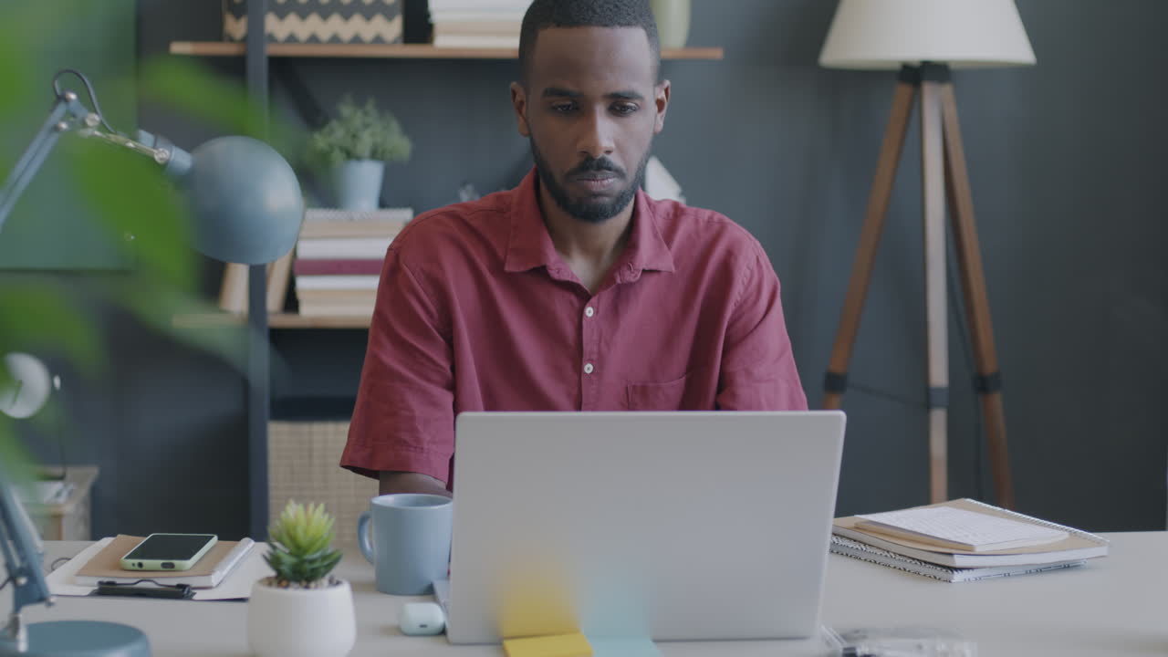 Man Working on Laptop in a Modern Home Office