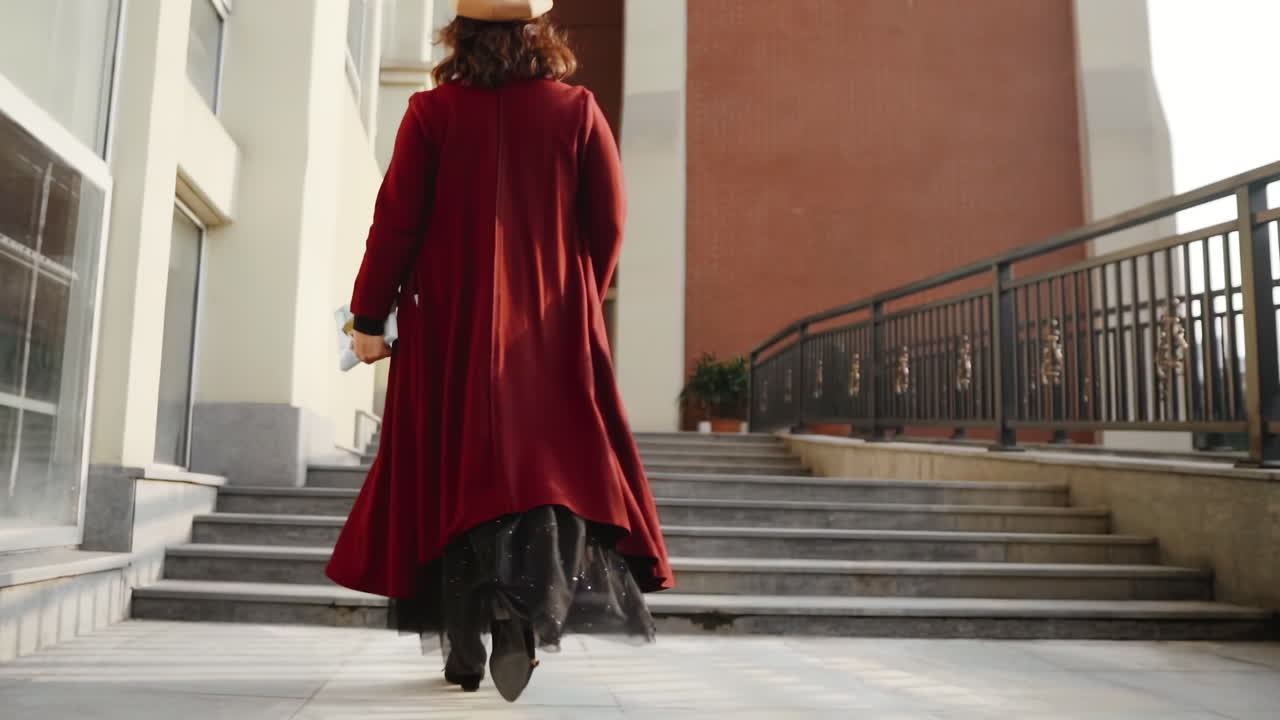 Giovane donna asiatica felice e sorridente, con vestiti alla moda ed eleganti e borse della spesa luminose e colorate, sta usando il suo smartphone mentre cammina nel centro commerciale.