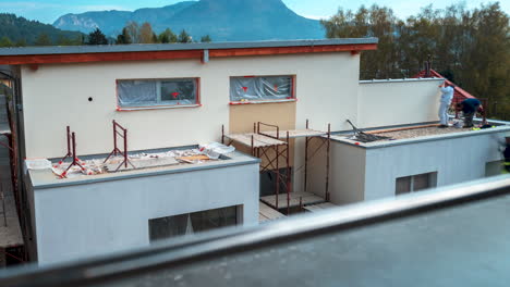 construction workers painting the exterior of a modern house