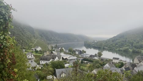 taal en el mosela pequeño pueblo en un río entre las montañas en alemania por la mañana con niebla