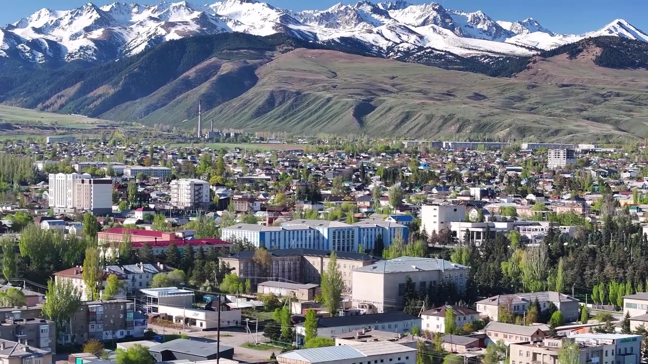 Kaunis droonikuva Karakolin kaupunkimaiseman panoraamasta, jossa näkyy kaupunkialue ja vuoria. Kirgisia.