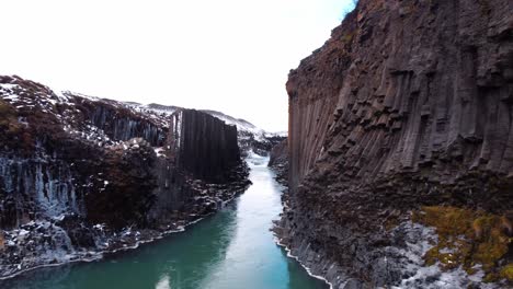 a compelling view captures the serene, turquoise-green river as it meanders through the awe-inspiring studlagil canyon