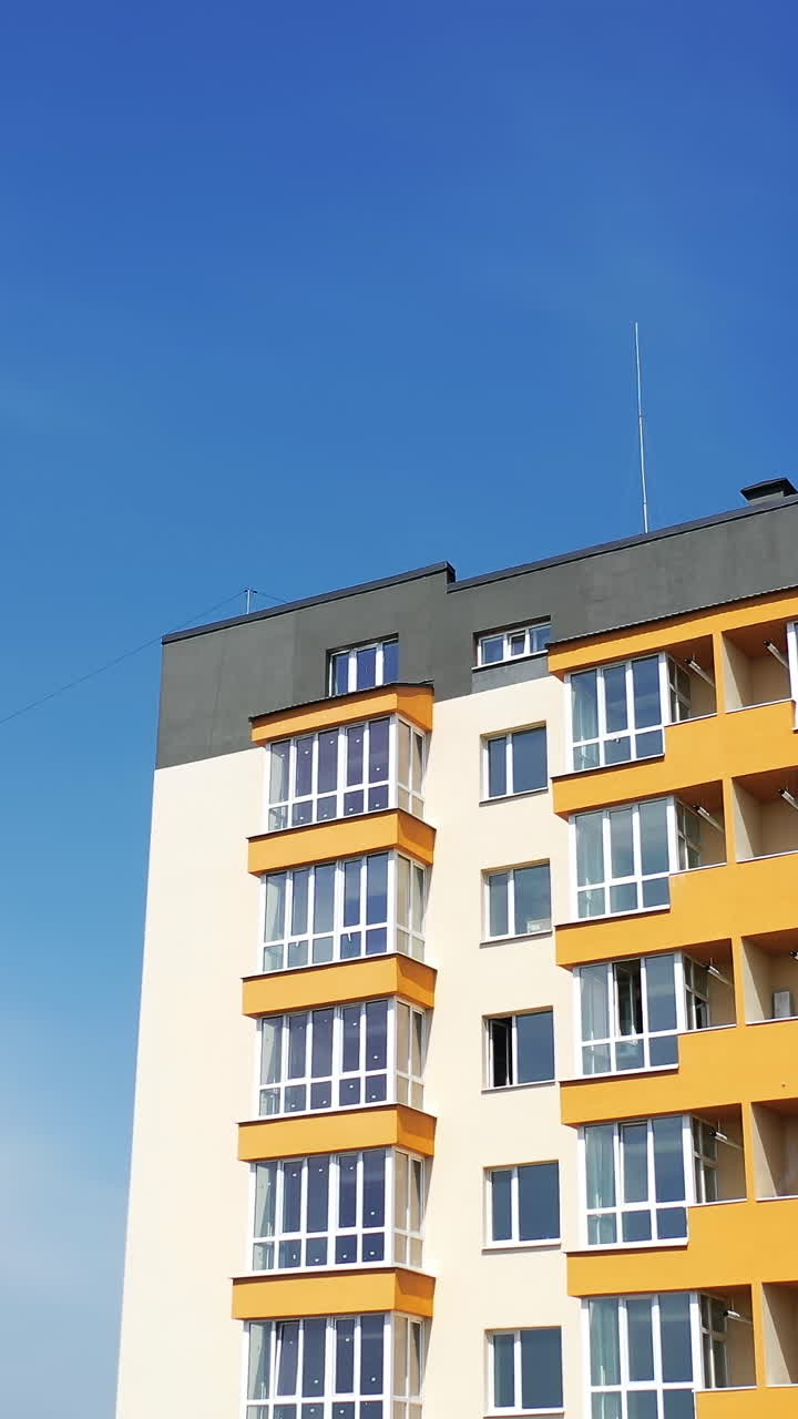 View from the drone of the contemporary residential building in the city. Exterior of a modern design of multistory apartment building. Aerial view. Vertical video