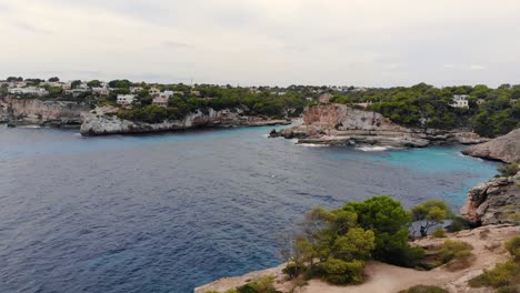 forward moving aerial over the crystal clear blue waters of mallorca island surrounded by rocky cliffs