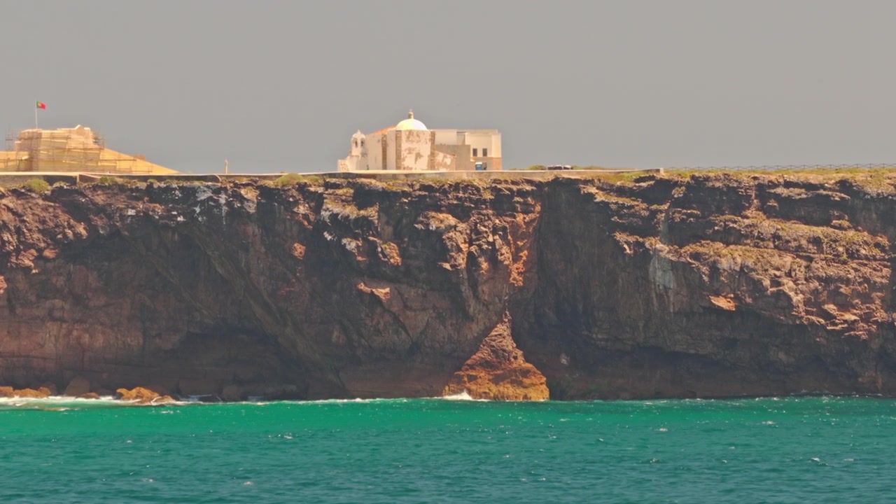 Riprese cinematografiche con drone di Sagres nella regione dell'Algarve in Portogallo, con spettacolari scogliere costiere, acque turchesi dell'Atlantico, formazioni rocciose frastagliate, spiagge incontaminate, Fortaleza de Sagres e panorami mozzafiato.