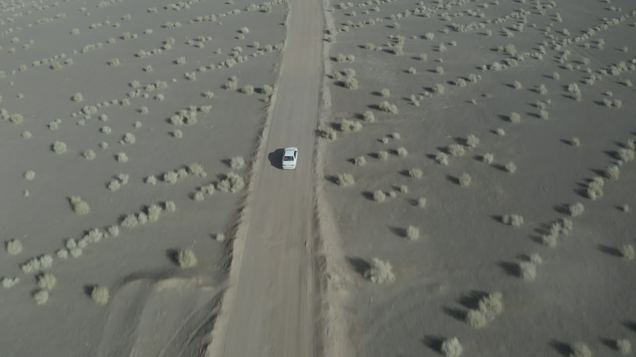 Driving a car across a sandy desert road in Iran, captured from above