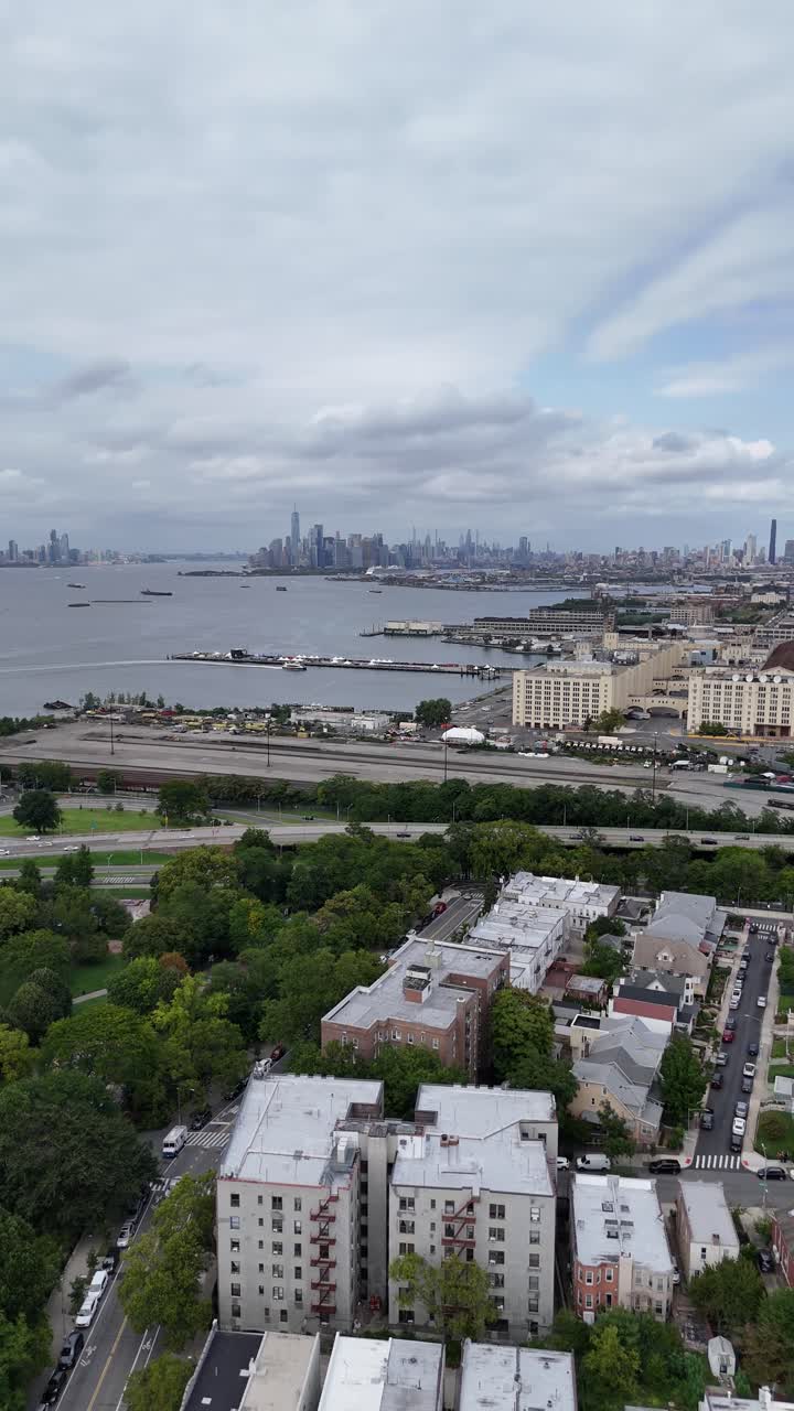 A sweeping drone panning shot from Senator Street in Brooklyn, revealing the coastline and surrounding urban landscape with a serene view of the waterfront.