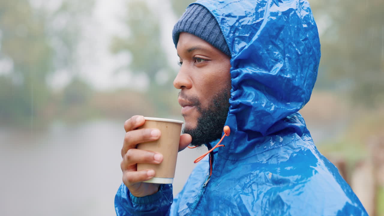 Campeggio, mattina e un uomo di colore che beve caffè