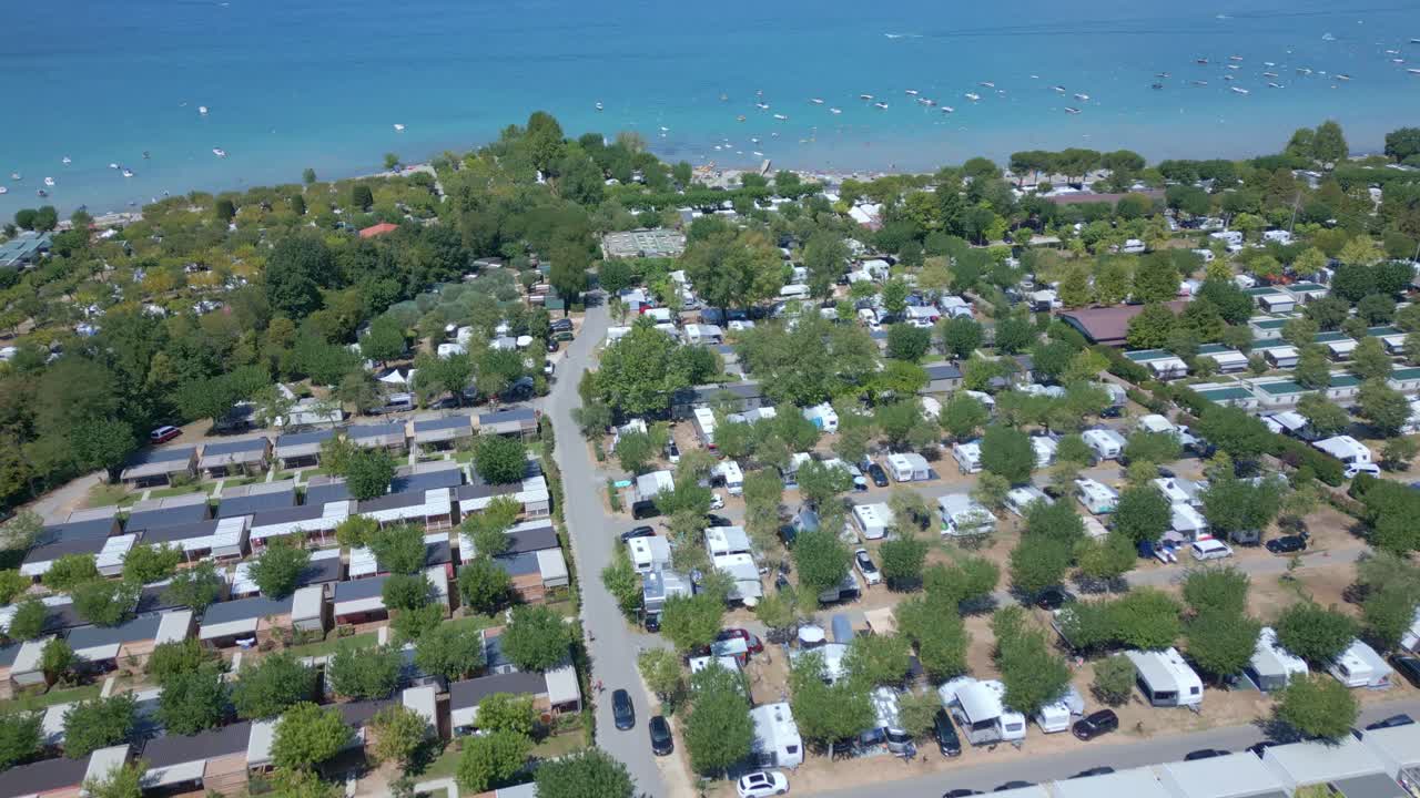 바다 앞 해변 옆에 rv와 캠퍼 밴이 늘어서 있습니다.