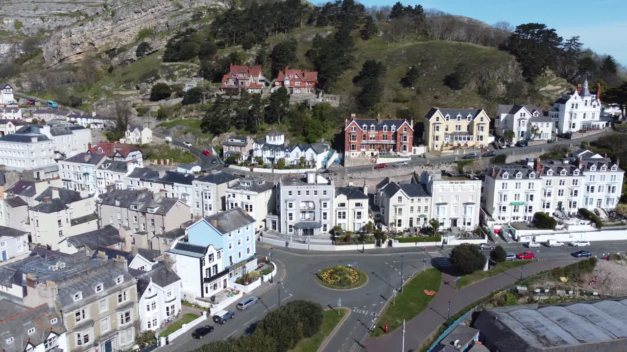 Colorati hotel della località turistica balneare di Llandudno sullo sfondo del monte Great Orme, con vista aerea, avvicinamento e rotazione a sinistra.