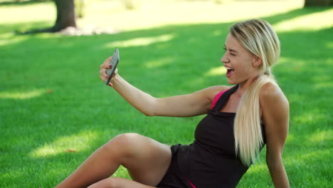 Mujer-Sonriente-Tomando-Una-Foto-Selfie-En-Un-Teléfono-Móvil-En-El-Parque.-Mujer-Fitness