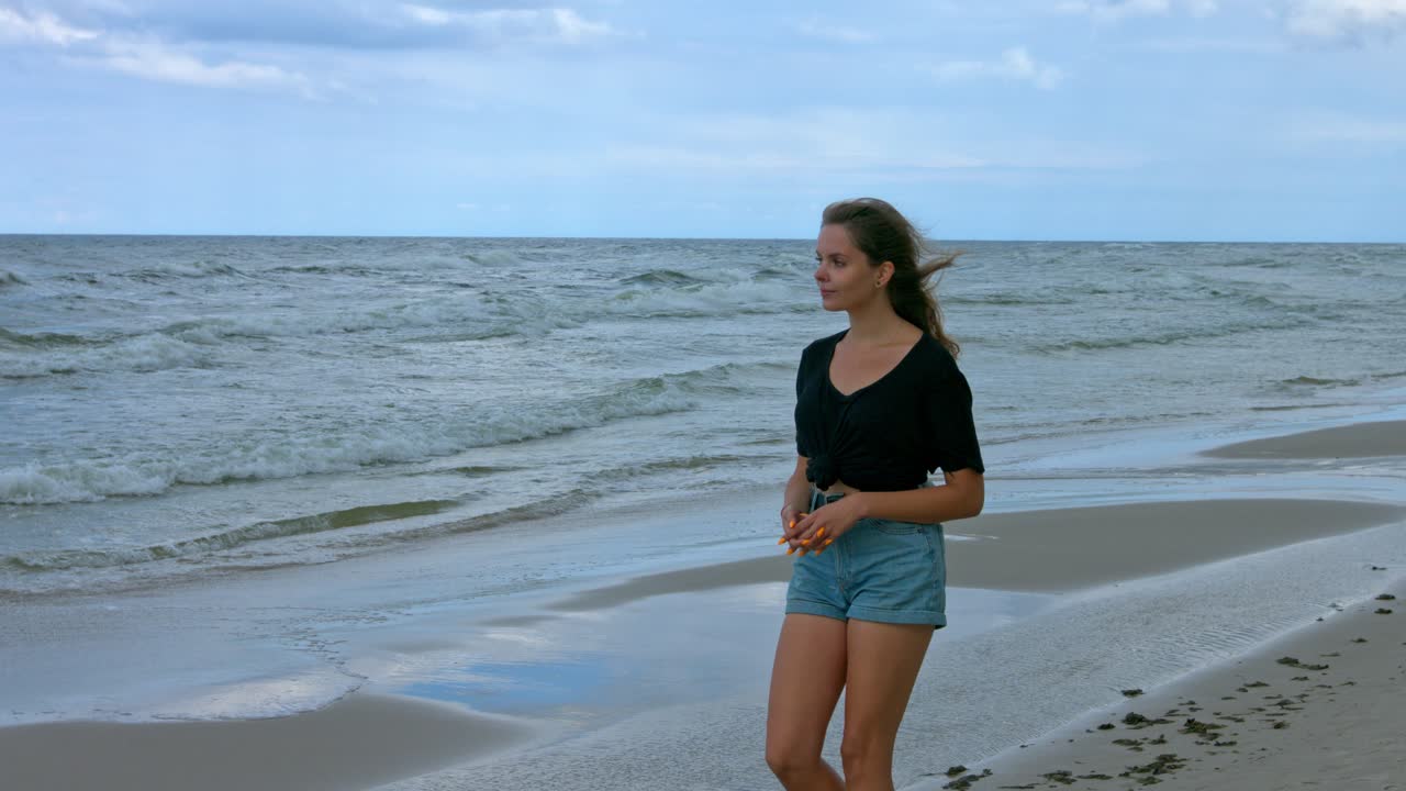 A teenager female walking alone at the beach seeing ocean wave in relaxation. A lonely young adult woman at the beach expressing happiness and freedom. a lady enjoying the peaceful walk at the ocean