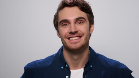 Man-smiling-at-camera-on-white-background.-Positive-guy-standing-in-studio