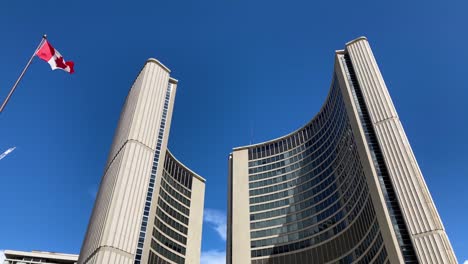 toronto city hall municipal government building looking up at canada flag blowing in the wind