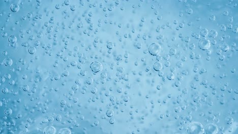 oxygen bubbles in water on a blue abstract background on super slow motion.