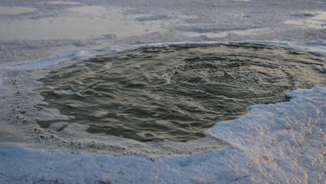 Close-up-shot-of-water-coming-out-of-a-small-puddle-in-the-Danakil-Salt-Flats