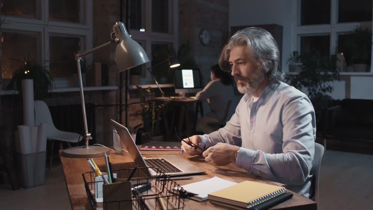 Professional man working late in office, experiencing stress and fatigue