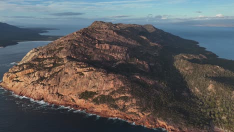 rocky mountain in freycinet national park surrounding coles bay in tasmania, australia. aerial drone panoramic view at sunset