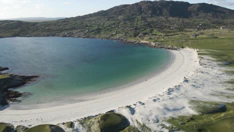 picturesque landscape of dog's bay beach surrounded by the coastal mountains and grassland in roundstone, county galway, connemara, ireland