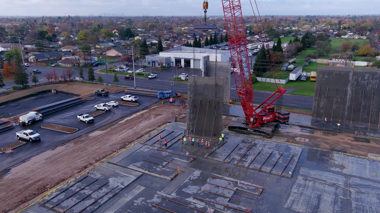 Concrete wall being placed in a industrial building with a crane