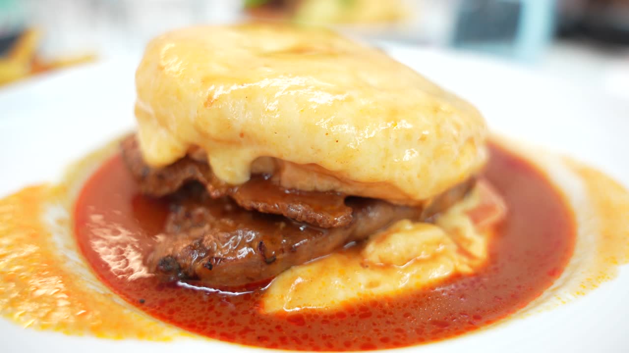 포르투의 전형적인 프란체신하 (francesinha) 를 시 ⁇ 레이션하는 아조레아닌하 (azoreaninha) 음식의 클로즈업 서클