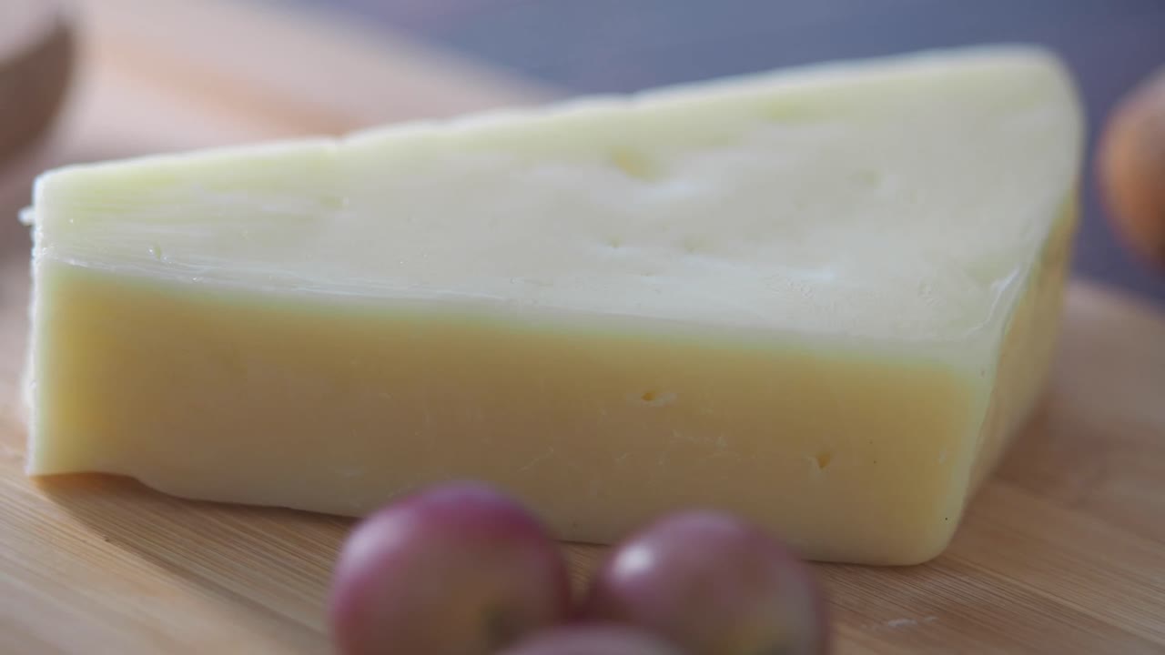 queso y uvas en una tabla para cortar