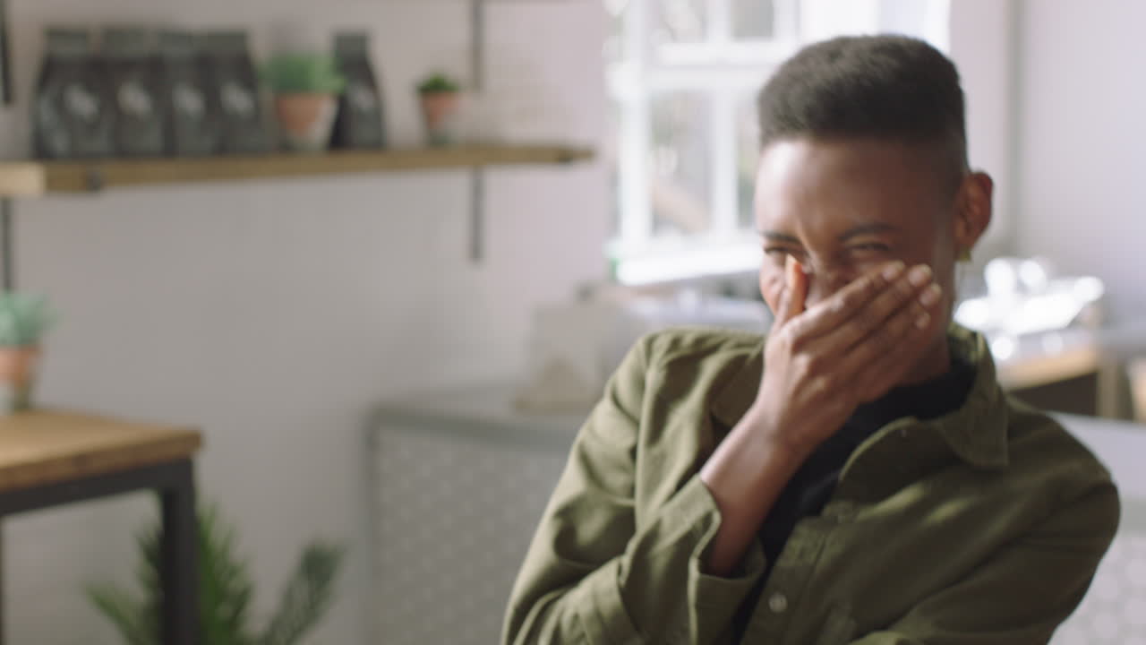 happy african american woman using tablet computer showing friend laughing together enjoying funny entertainment on mobile device screen in coffee shop