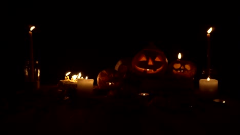 three jack pumpkins in candlelight on a dark background, loop video