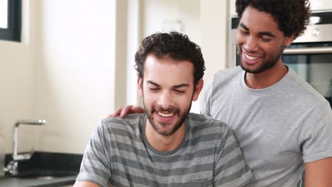 Happy-homosexual-couple-using-computer