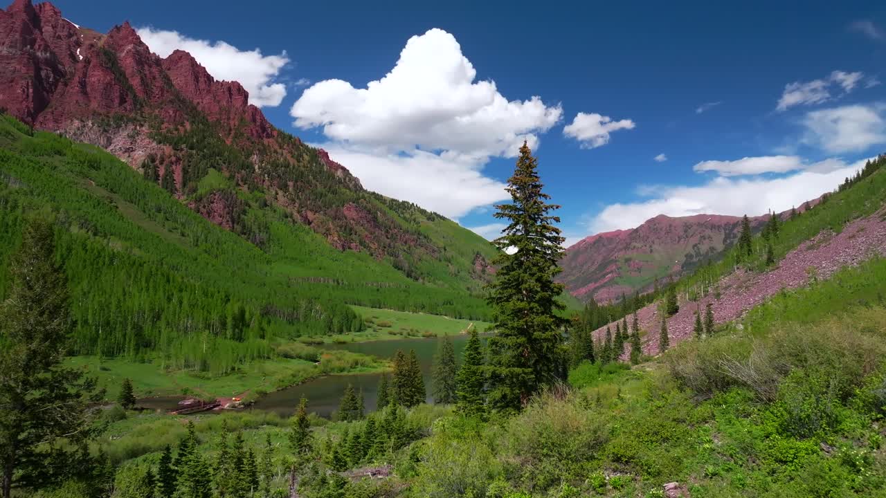 Maroon Lake Crater Lake Aspen Snowmass Maroon Bells Wilderness spring summertime sunny morning blue sky aerial drone Colorado Red steep Rocky Mountains Elk Range Mountains Maroon Creek upwards