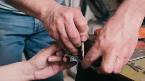 man and woman helping each other in measuring a metal sheet to cut