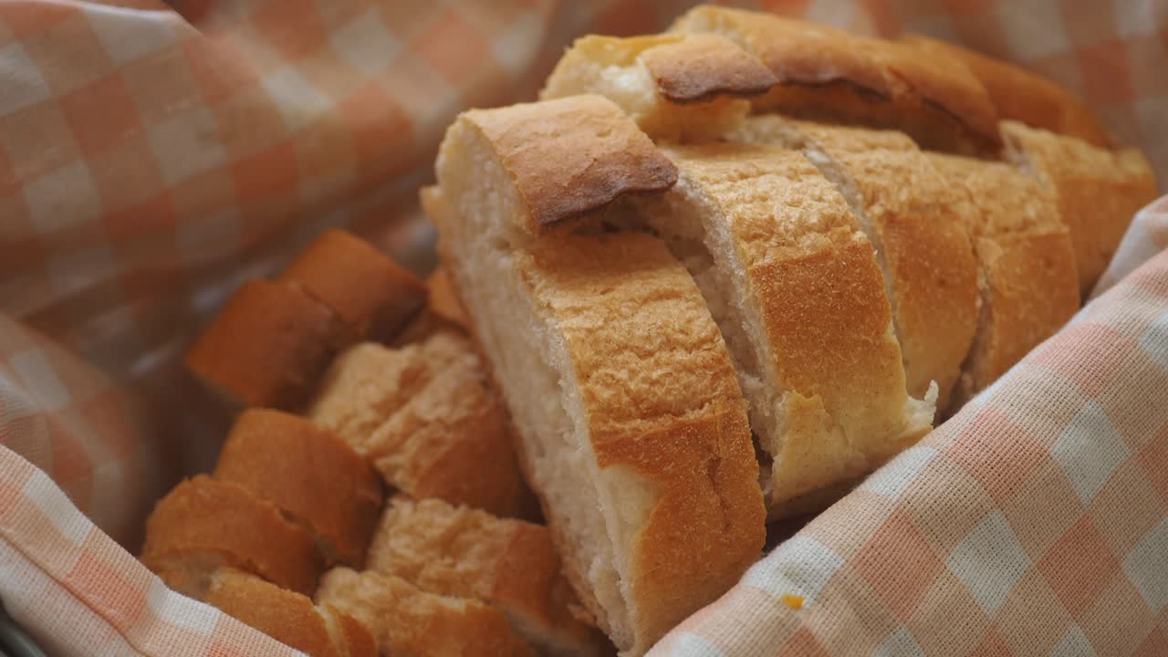 Hand Picking a Slice of Freshly Baked Bread from a Basket