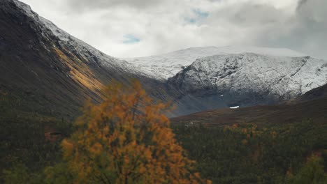 a magnificent norwegian tundra autumn valley framed by the snow-covered mountains