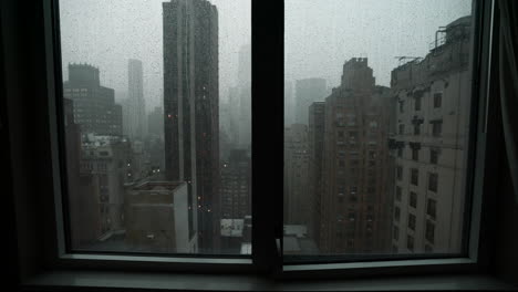 heavy rain running down a new york city window with a view of the manhattan skyline on a cloudy, rainy day