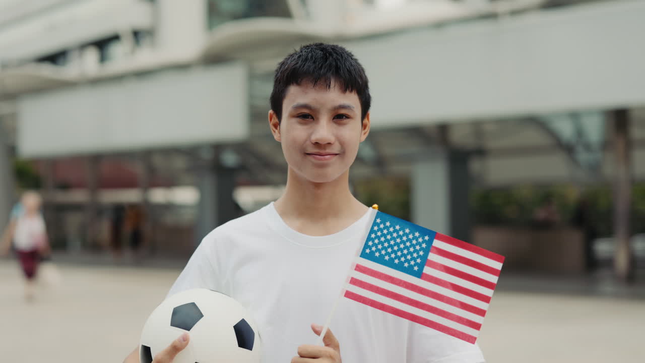 Teenager holding American flag and soccer ball