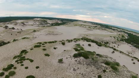 una toma aérea pintoresca de arriba hacia abajo de senderos áridos, dunas de arena y laderas empinadas con un pequeño follaje tupido ubicado en el sendero de chozas de dunas en la provincia de cape cod, massachusetts