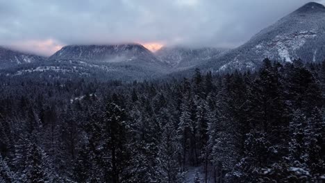 flying low over frozen forest in the rocky mountains