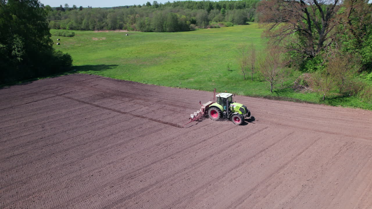 Tractor ploughing field in summer, Latvia