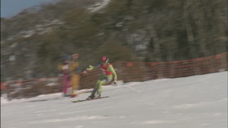 a skier skis downhill as people watch